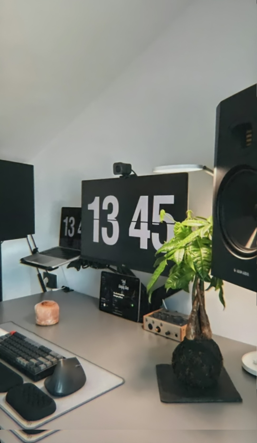 Hands typing on teal mechanical keyboard with monitors in background